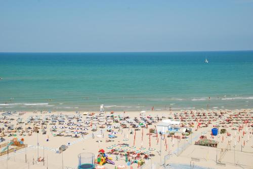 a beach filled with lots of people and the ocean at B&B AL MARE in Porto San Giorgio