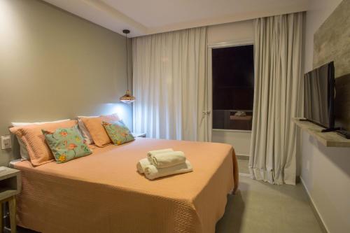 a bedroom with a bed with towels on it at Pousada Renda do Mar in Morro de São Paulo