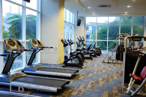 a row of treadmills in a gym with windows at Paragon Residences Straits View Homestay by WELCOME HOME in Johor Bahru