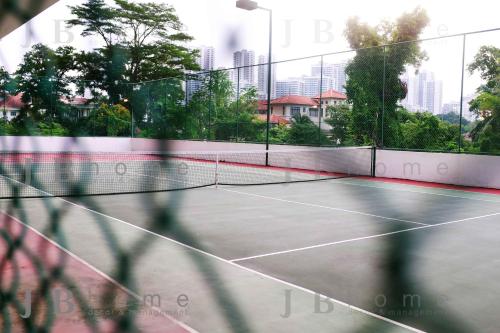 a tennis court with a net and buildings in the background at Paragon Residences Straits View Homestay by WELCOME HOME in Johor Bahru