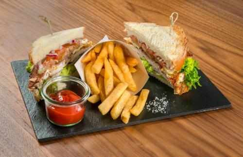 a black plate with a sandwich and french fries andetchup at Mercure Hai Phong in Hai Phong