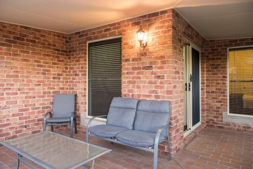 two chairs and a table on a brick patio at Colonial Court House in Mudgee