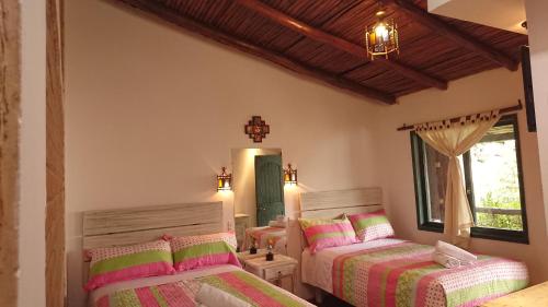 a bedroom with two beds and a mirror at Villa Mimi in Otavalo
