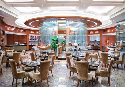 een restaurant met tafels en stoelen en een bar bij Cinese Hotel Dongguan Shijie in Dongguan