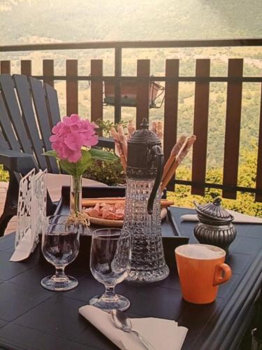 a black table with flowers and glasses on a balcony at A Casa di Gianni e Mari in Vestone