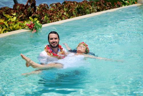 a man and a woman in a swimming pool at Taveuni Island Resort & Spa in Matei