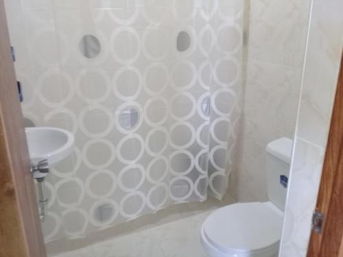 a bathroom with a shower with a toilet and a sink at JoSurfInn, Puraran Beach in Baras