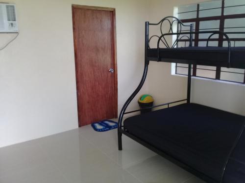 ein Schlafzimmer mit einem Etagenbett und einer Tür in der Unterkunft JoSurfInn, Puraran Beach in Baras