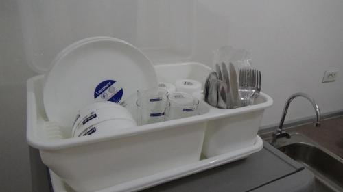a refrigerator filled with lots of dishes and a sink at Cozy 1BR-Grace Residences in Manila