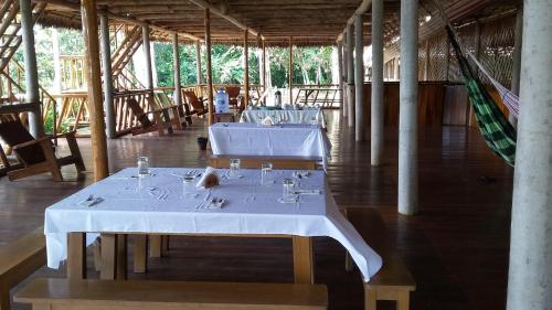 un comedor con 2 mesas en un edificio en Tres Chimbadas Lake Lodge, en Tambopata