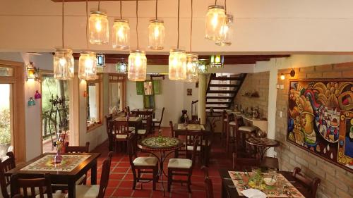 a restaurant with tables and chairs and chandeliers at Villa Mimi in Otavalo