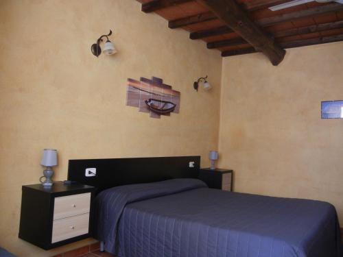 a bedroom with a bed and two lamps on the wall at Azienda Agrituristica Le Betulle in Riotorto