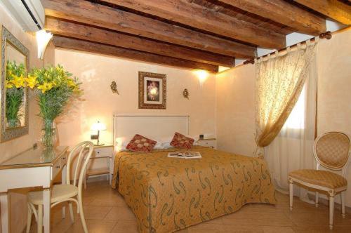 a bedroom with a bed and a table and chairs at Ca' Dei Leoni in Venice