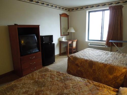 a hotel room with two beds and a television at Red Carpet Inn Brooklyn in Brooklyn