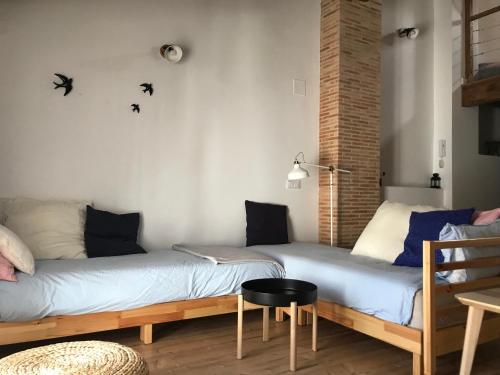 two beds in a room with a chair and a table at Casa La Abuela in Chulilla