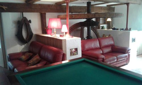 a living room with a pool table and couches at Le moulin de Varax in Saint-Paul-de-Varax
