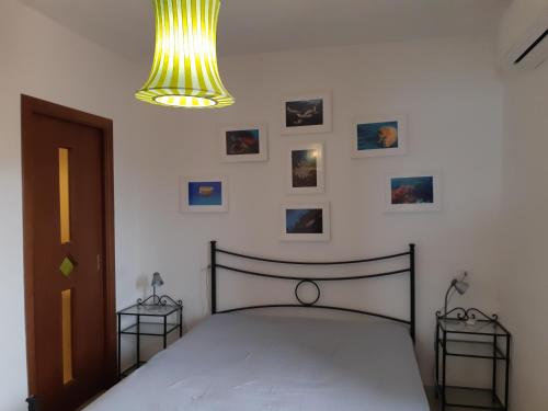 a bedroom with a bed and a chandelier and pictures at Campese Apartments in Campese