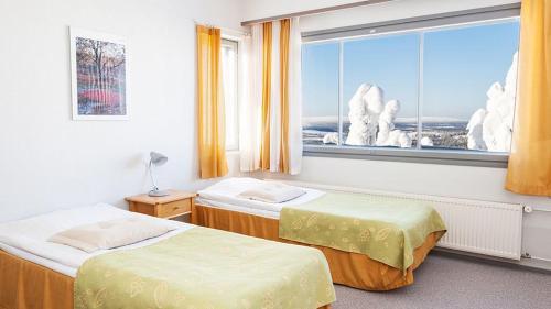Cette chambre comprend deux lits et une grande fenêtre. dans l'établissement Hotelli Pikku-Syöte, à Syöte