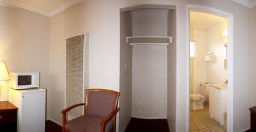 a room with a chair and a room with a microwave at Sunset Inn and Suites West Sacramento in West Sacramento