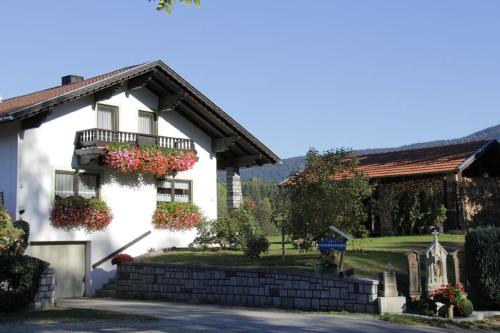 a white house with flowers on the side of it at Ferienwohnung Achatz Josef sen in Arnbruck