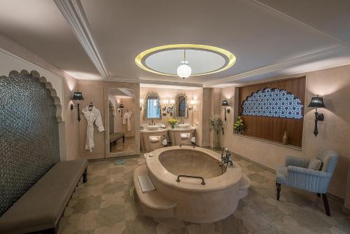 a bathroom with a large tub and a sink at Fairmont Jaipur in Jaipur