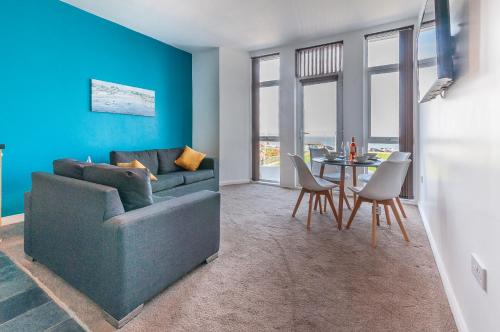 a living room with a couch and a table at Five Way Apartments in Paignton