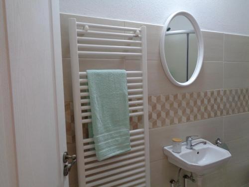a bathroom with a sink and a mirror and a towel at Alexandra Studios in Sibiu