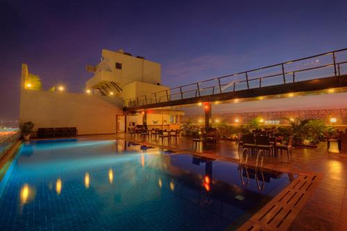 a swimming pool on the roof of a building at night at Hotel Parc Estique in Pune