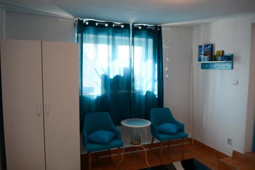 two blue chairs and a table in a room at Sailors Guest House Jurilovca in Jurilovca