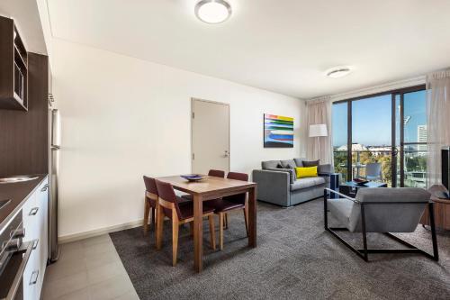 a living room filled with furniture and a kitchen at Quest at Sydney Olympic Park in Sydney