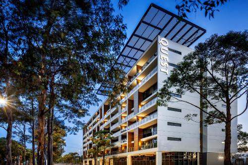 a building with a sign on the side of it at Quest at Sydney Olympic Park in Sydney