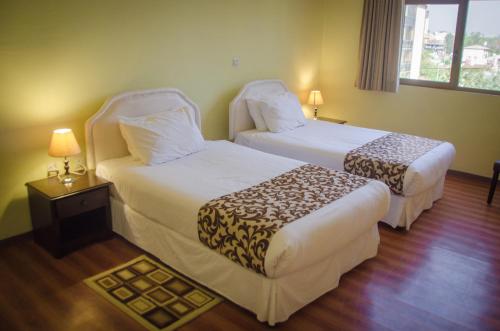 una camera d'albergo con due letti e una finestra di Union Hotel Apartments ad Addis Abeba