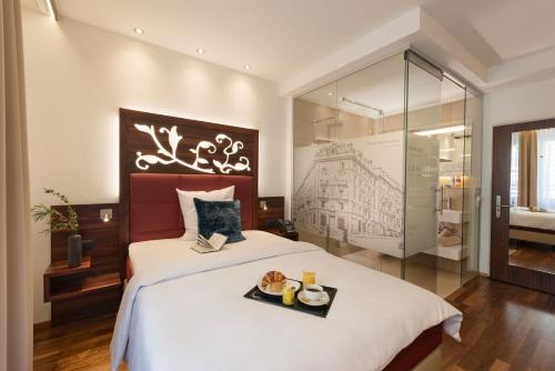 a bedroom with a bed with a tray of food on it at Hotel Scheuble in Zürich