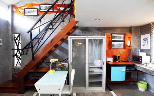 a room with a staircase with a desk and a table at Phuket Paradiso in Chalong 