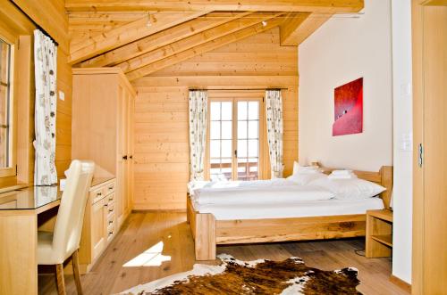 a bedroom with a large bed in a wooden room at Chalet Princess - GRIWA RENT AG in Grindelwald