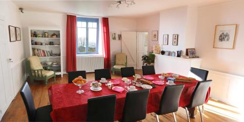 a dining room with a red table and chairs at Maison d'hotes Sainte Genevieve in Sainte-Geneviève