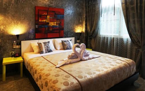 a bedroom with a bed with two swans on it at Phuket Paradiso in Chalong 