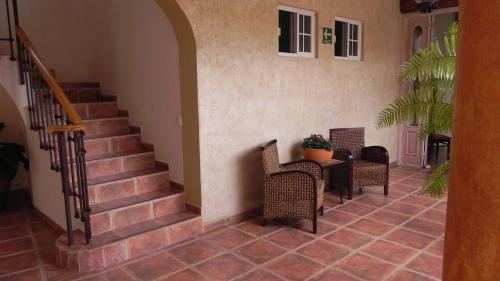 a hallway with chairs and a table and stairs at Hotel Boutique La Granja in Tequisquiapan