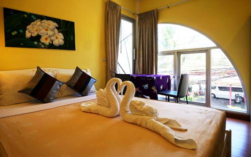 a bedroom with two swans towels on a bed at Phuket Paradiso in Chalong 