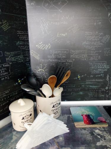 a table with a blackboard with a cup and utensils at Aura in Primorsko