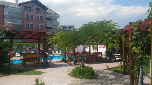 a resort with a pool and palm trees and a building at Aura in Primorsko