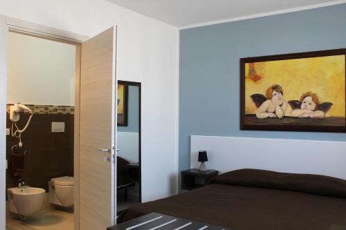 a bedroom with a bed and a painting on the wall at Borgo Aranci - Appartamento in Villa Orchidea - 12A in Castellammare del Golfo