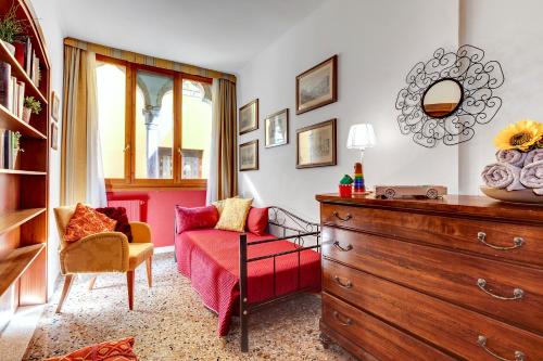 soggiorno con cassettiera e sedia rossa di CasaMisa Paste a Venezia