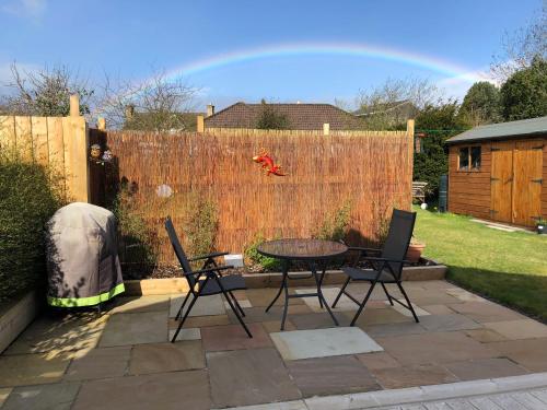 a patio with a table and chairs and a fence at The Wee Lodge in Inverness