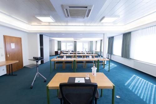 a room with rows of tables and chairs at Hotel Krupp in Bad Neuenahr-Ahrweiler