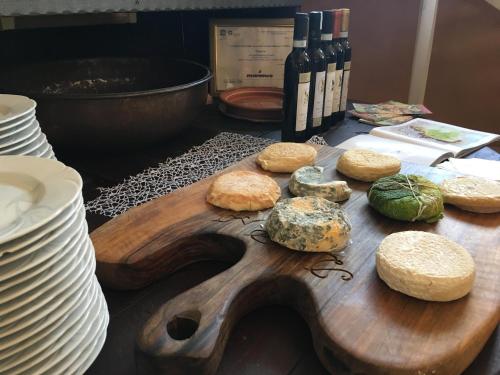 a wooden cutting board with bread and bottles of wine at Albergo Rondò in Acqui Terme