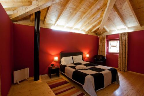 um quarto com uma cama grande numa parede vermelha em Aldeia Do Pontido em Fafe