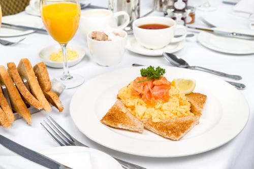 a white plate of food on a table with toast at Grinkle Park Hotel in Loftus