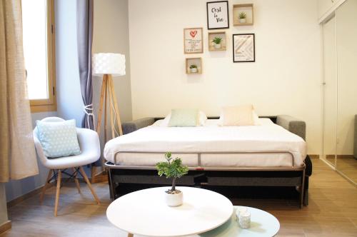 a bedroom with a bed and a table and a chair at Le Mattoni 2 in Menton