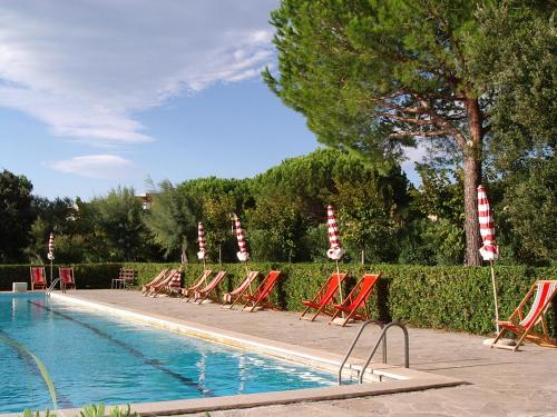 uma fila de cadeiras de jardim junto a uma piscina em Marina Di Bibbona em Marina di Bibbona